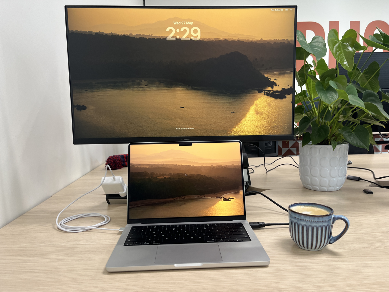 Hot desk at Powerhouse Coworking with 27-inch monitor and a MacBook slid underneath for dual-screen use